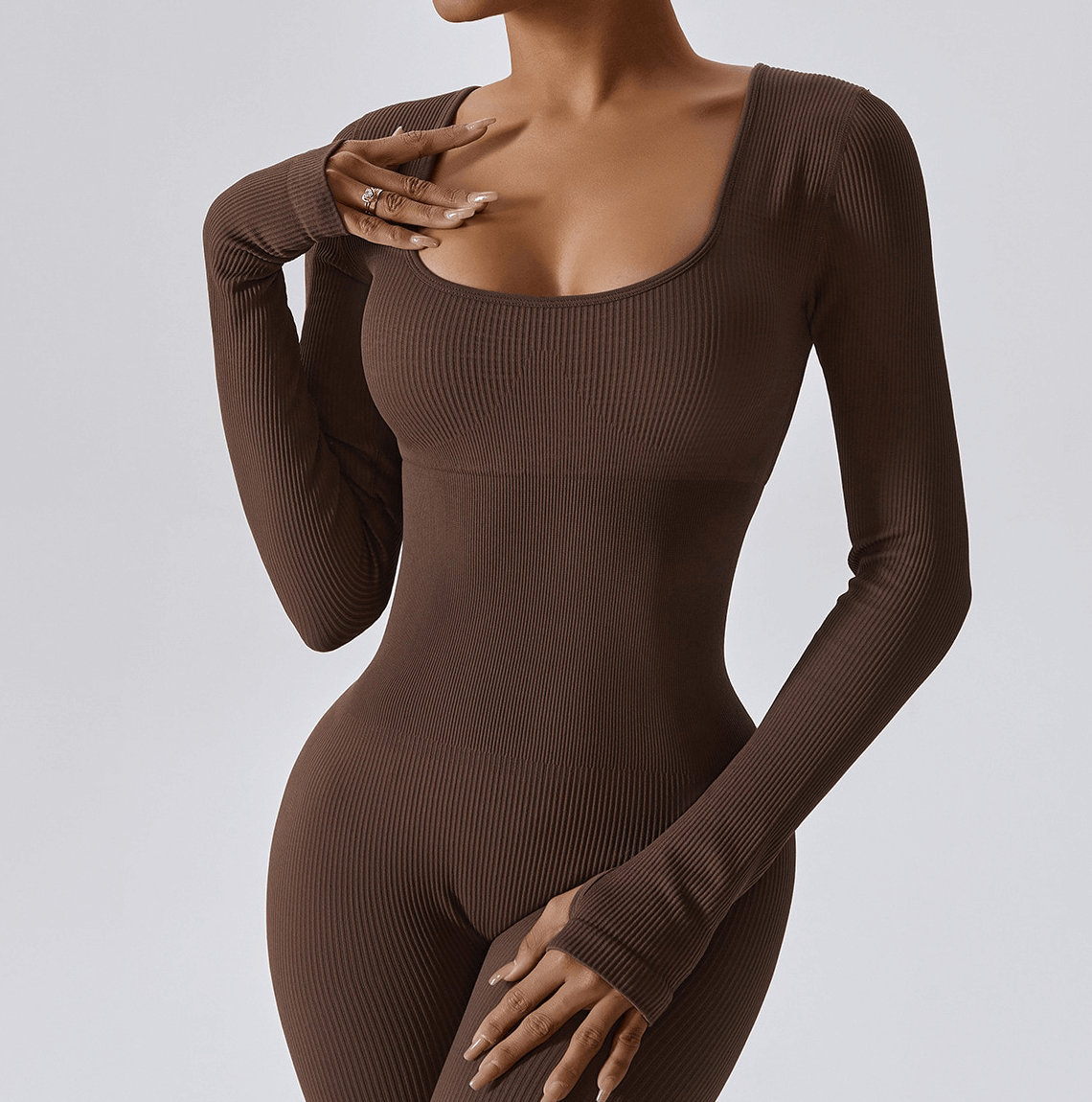 Woman wearing seamless brown yoga suit with thumb holes, perfect for fitness and yoga sessions.